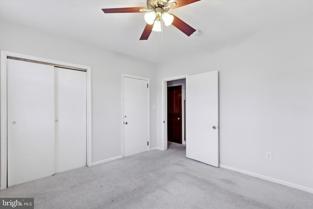 unfurnished bedroom featuring light carpet, a closet, and ceiling fan