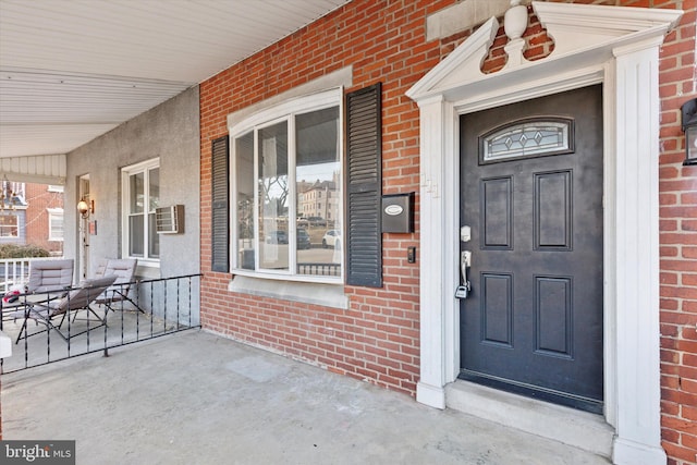 view of exterior entry featuring covered porch