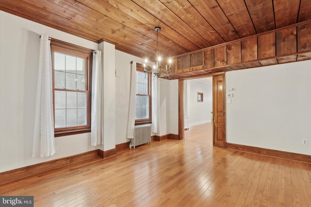 spare room with radiator heating unit, wood ceiling, a notable chandelier, and light hardwood / wood-style flooring