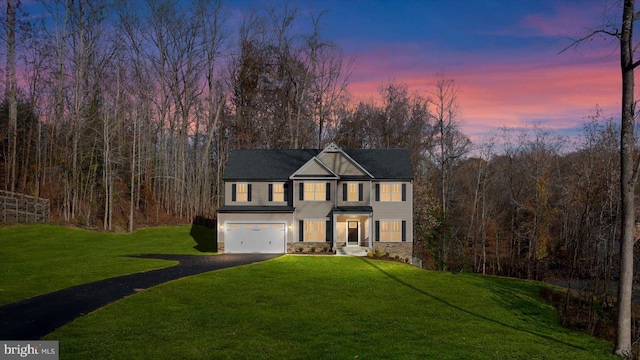 view of front of home with a garage and a lawn