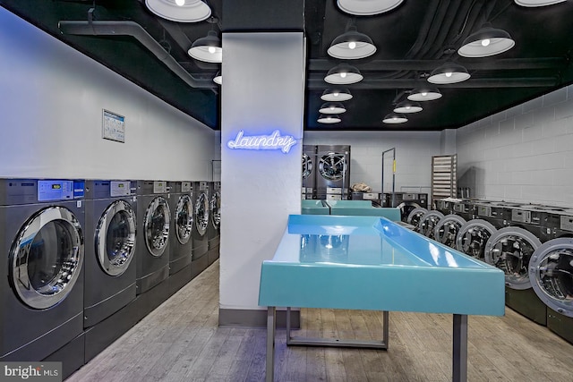 laundry room with washer and clothes dryer and hardwood / wood-style floors