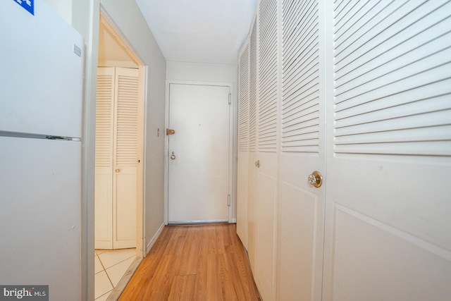 hallway with light hardwood / wood-style floors