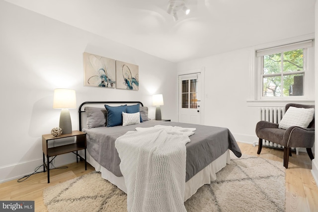 bedroom with light wood-type flooring and radiator