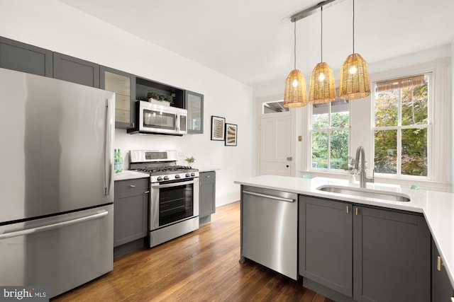 kitchen featuring sink, decorative light fixtures, gray cabinetry, and appliances with stainless steel finishes