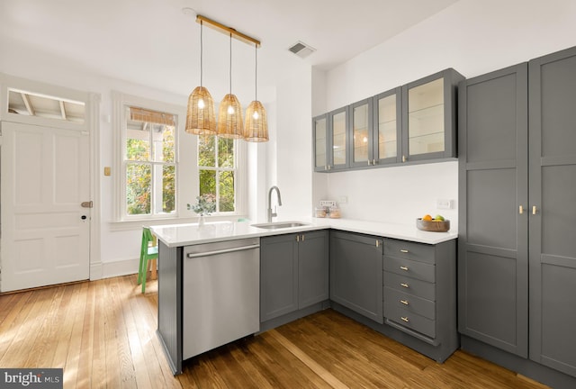 kitchen with dishwasher, dark wood-type flooring, sink, gray cabinets, and kitchen peninsula