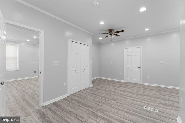 interior space featuring ceiling fan, ornamental molding, and light wood-type flooring