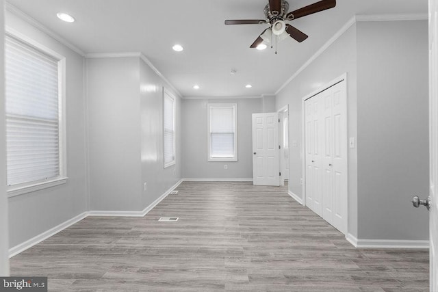 unfurnished room featuring light hardwood / wood-style floors, ceiling fan, and ornamental molding