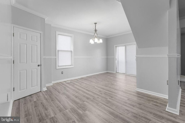 interior space featuring light hardwood / wood-style floors, crown molding, a healthy amount of sunlight, and a notable chandelier