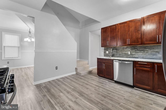 kitchen featuring an inviting chandelier, light hardwood / wood-style flooring, backsplash, decorative light fixtures, and appliances with stainless steel finishes