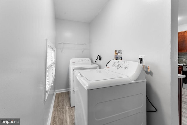 laundry area with washer and dryer and light wood-type flooring