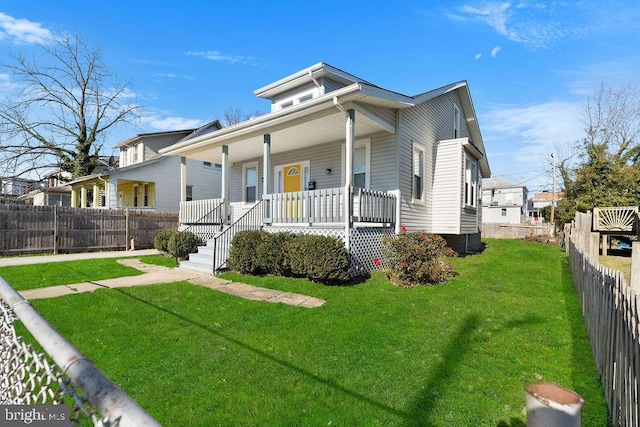 view of front of property with covered porch and a front yard