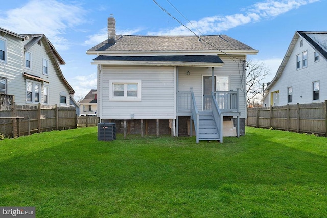 back of property with a lawn and central air condition unit