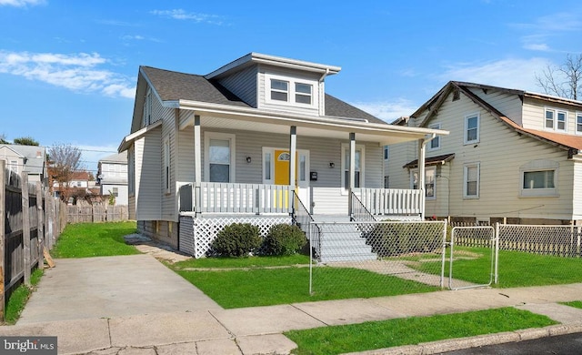 bungalow with covered porch and a front yard