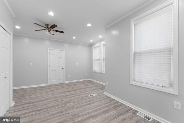 empty room with light wood-type flooring, ceiling fan, and ornamental molding