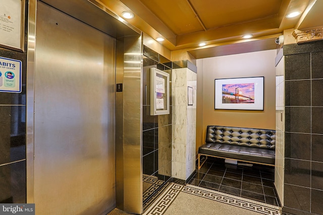 interior space with elevator and dark tile patterned flooring