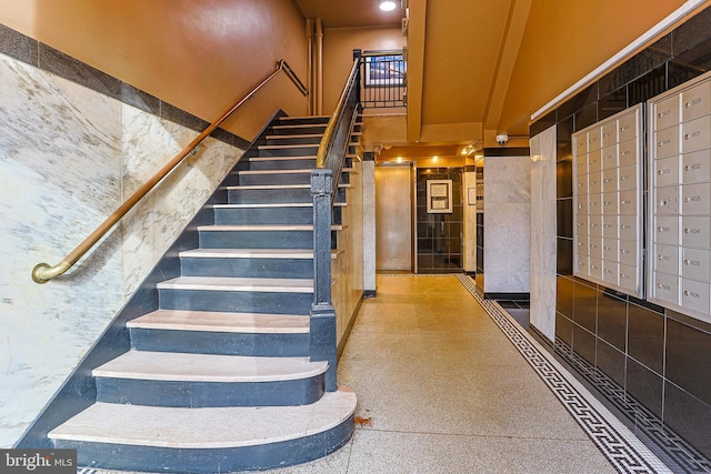 staircase featuring a mail area