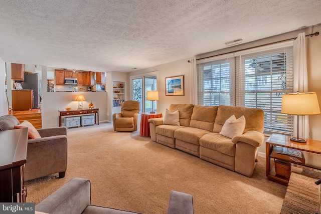 carpeted living room featuring a textured ceiling