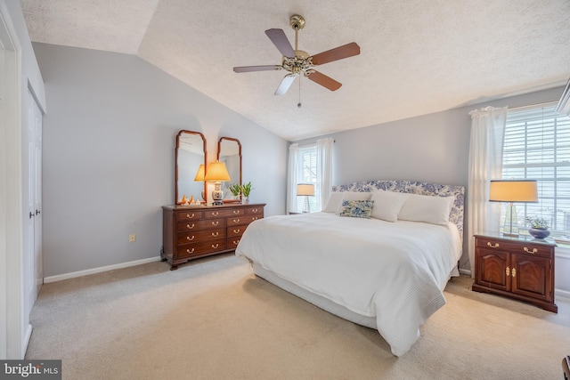 bedroom featuring ceiling fan, lofted ceiling, light colored carpet, and multiple windows