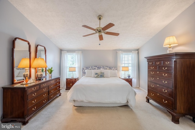 bedroom featuring lofted ceiling, light carpet, a textured ceiling, and ceiling fan