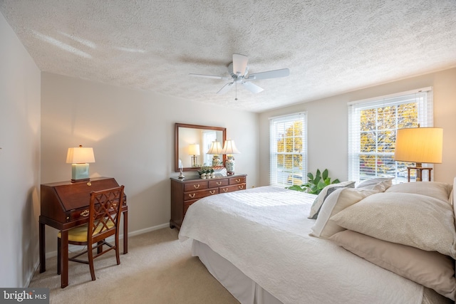 carpeted bedroom with a textured ceiling and ceiling fan