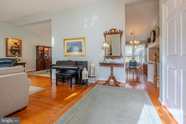 misc room featuring vaulted ceiling with beams, wood-type flooring, and a chandelier