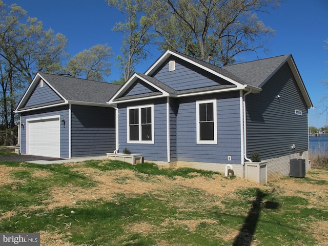 1240 Shore Dr, Colonial Beach, VA 22443 - ranch-style home with cooling unit, a garage, roof with shingles, and a front lawn