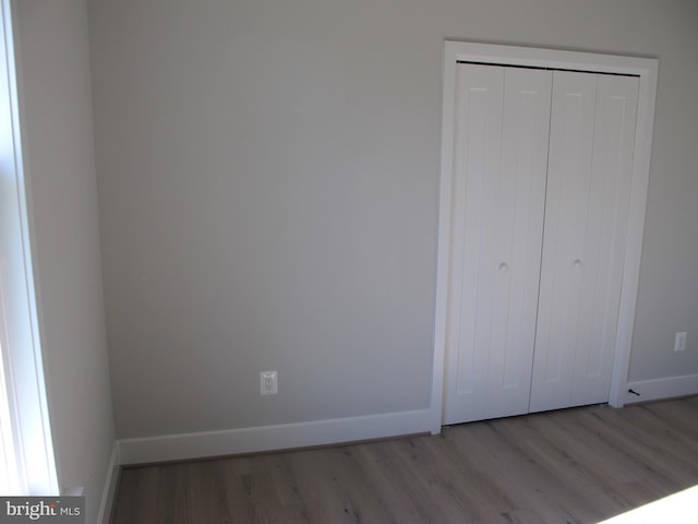 1240 Shore Dr, Colonial Beach, VA 22443 - unfurnished bedroom featuring wood finished floors, a closet, and baseboards