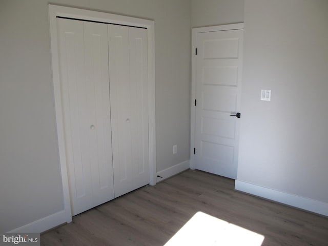 1240 Shore Dr, Colonial Beach, VA 22443 - unfurnished bedroom with wood finished floors, baseboards, and a closet