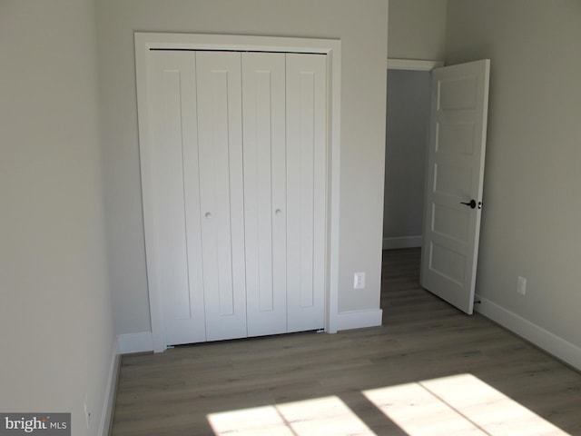 1240 Shore Dr, Colonial Beach, VA 22443 - unfurnished bedroom featuring a closet, wood finished floors, and baseboards