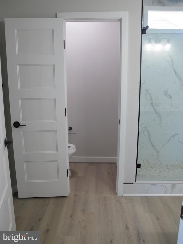 1240 Shore Dr, Colonial Beach, VA 22443 - bathroom with a marble finish shower, toilet, wood finished floors, and baseboards