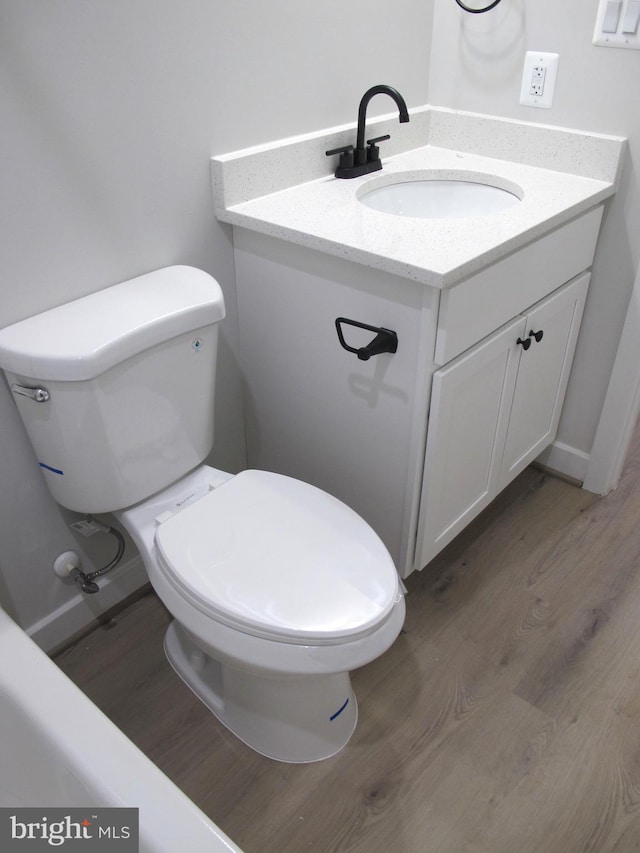 1240 Shore Dr, Colonial Beach, VA 22443 - half bath with vanity, wood finished floors, and toilet