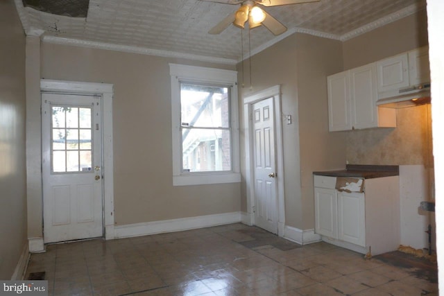 kitchen with white cabinets, ceiling fan, and crown molding