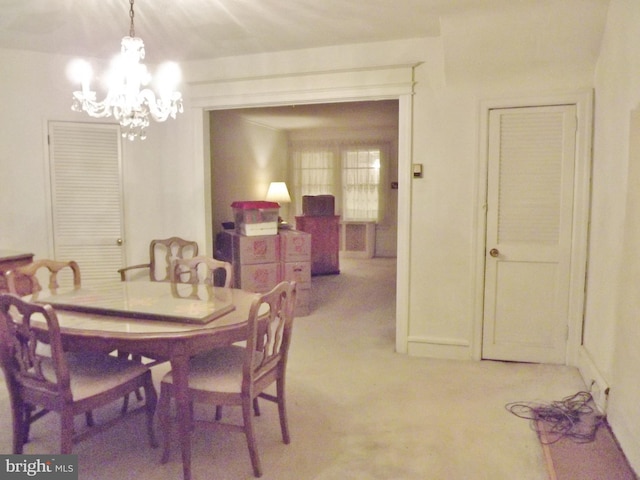 carpeted dining space featuring an inviting chandelier