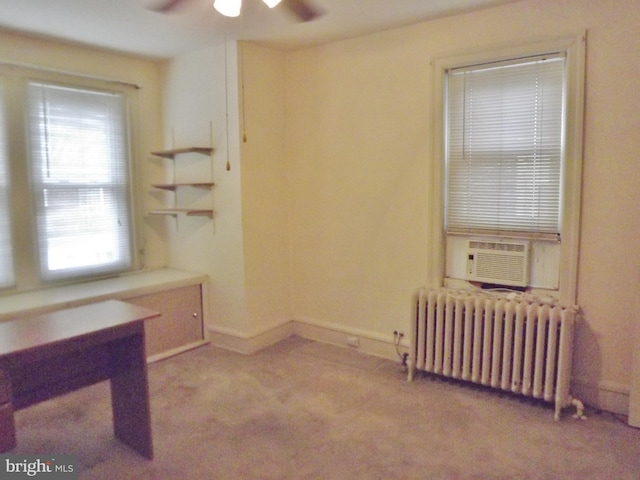 office with ceiling fan, cooling unit, radiator heating unit, and light carpet