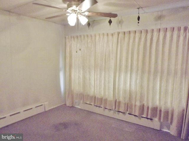 carpeted spare room with baseboard heating and ceiling fan