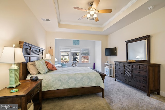 bedroom featuring a tray ceiling, ceiling fan, carpet, and ornamental molding