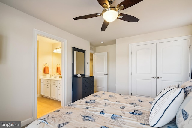 bedroom with ceiling fan, a closet, ensuite bathroom, and sink