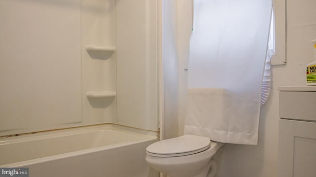 bathroom featuring washtub / shower combination and toilet