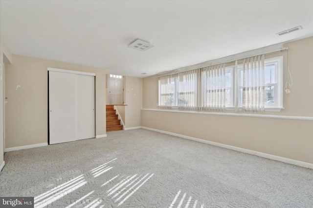 unfurnished bedroom featuring light carpet and a closet