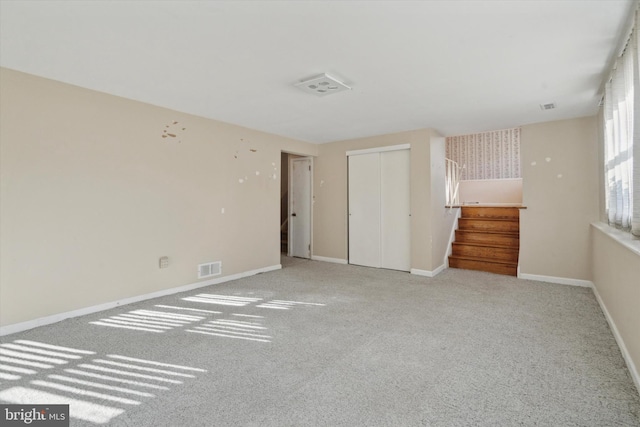 unfurnished bedroom with light carpet and a closet