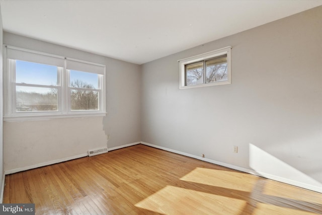 spare room with a healthy amount of sunlight and hardwood / wood-style flooring