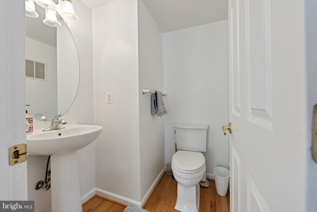 bathroom featuring sink, wood-type flooring, and toilet