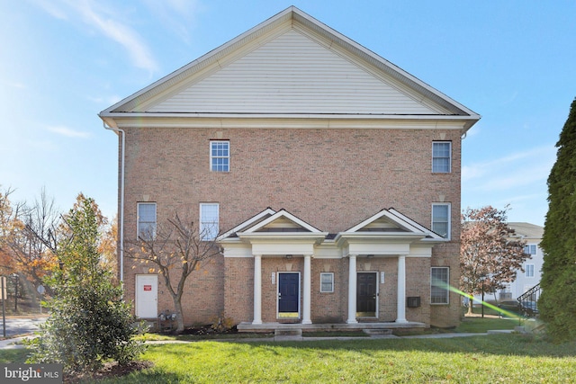 greek revival house featuring a front yard