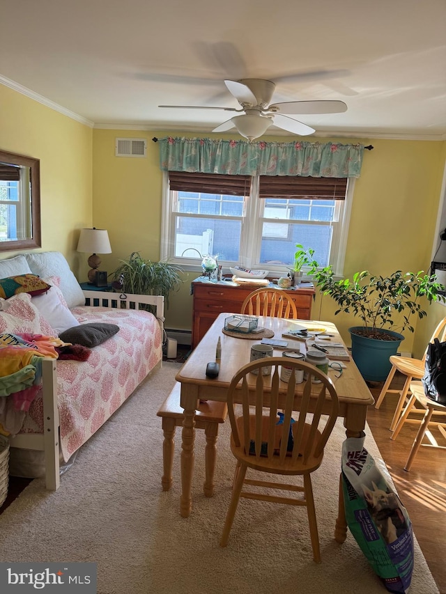 bedroom with ceiling fan, crown molding, and a baseboard heating unit