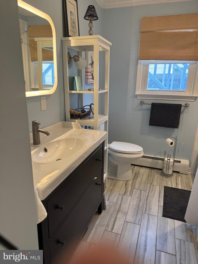 bathroom featuring vanity, toilet, baseboard heating, and ornamental molding