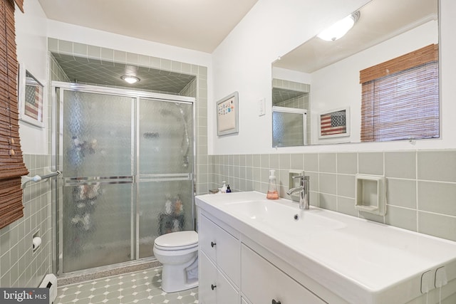 bathroom featuring an enclosed shower, vanity, toilet, and tile walls