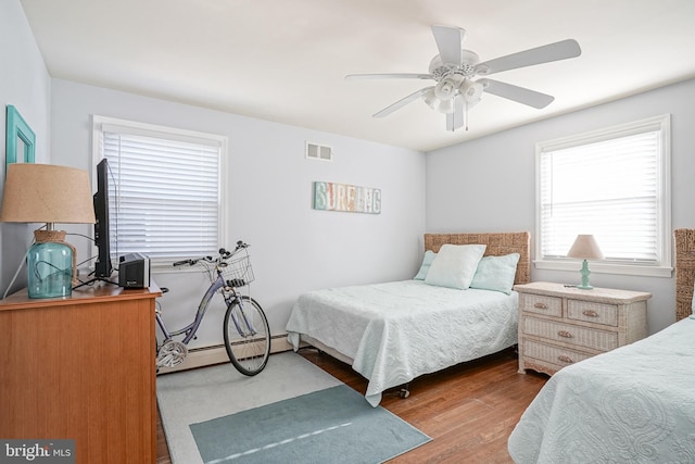 bedroom with ceiling fan, light hardwood / wood-style flooring, and a baseboard radiator