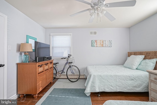 bedroom featuring ceiling fan, dark hardwood / wood-style floors, and a baseboard radiator