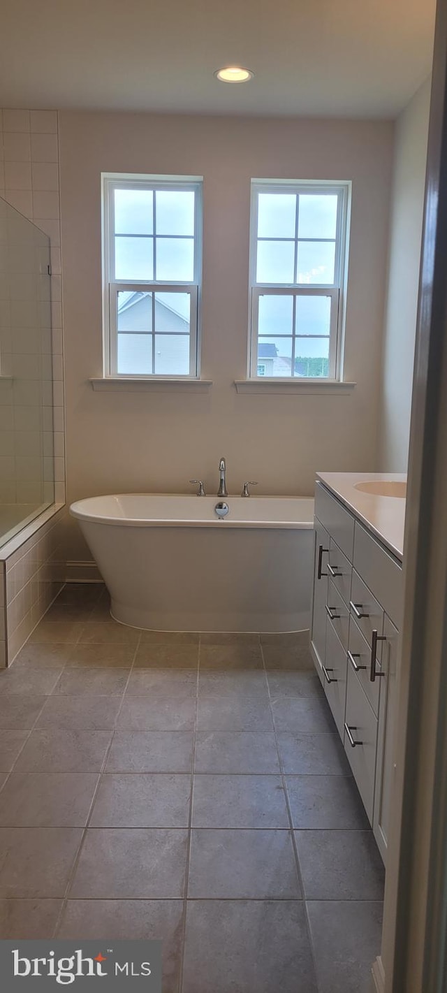 bathroom featuring plenty of natural light, vanity, independent shower and bath, and tile patterned flooring