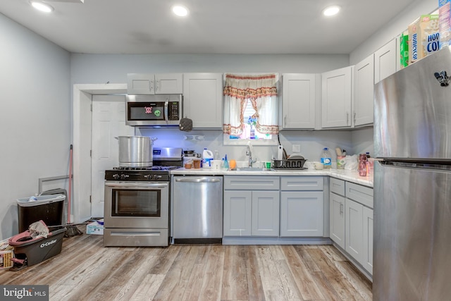 kitchen featuring sink, appliances with stainless steel finishes, and light hardwood / wood-style flooring